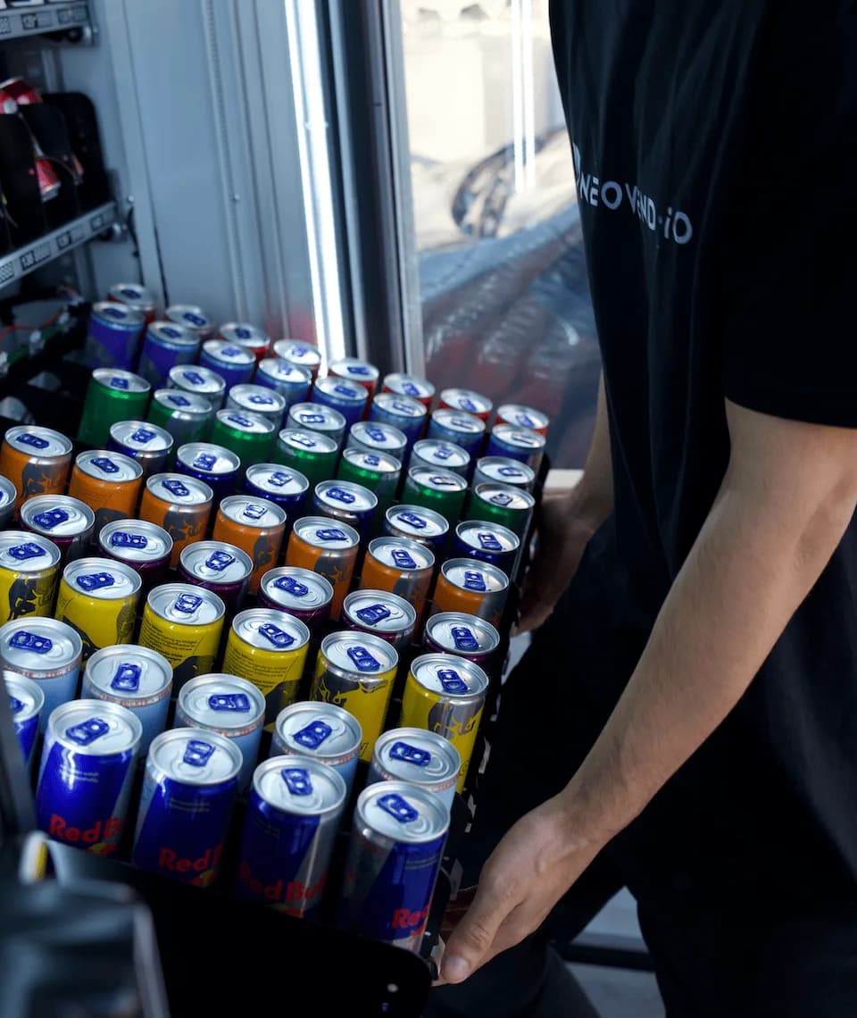 Nachfüllen eines NEOVEND-Automaten: eine Lage Energydrinks wird in das offene Gerät gesetzt